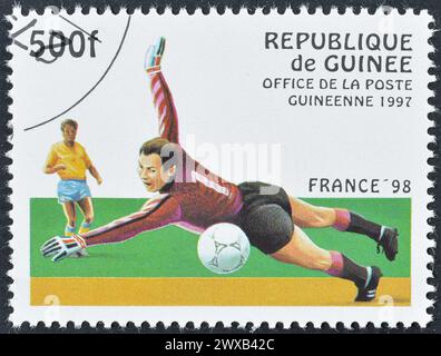 Von Guinea gedruckte Briefmarke mit Stempelabdruck, die Fußballspieler zeigt, die die FIFA-Weltmeisterschaft 98 in Frankreich um 1997 bewerben. Stockfoto