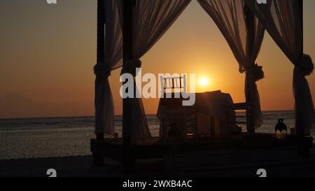 Silhouette eines romantischen Restaurants direkt am Strand mit Blick auf den Sonnenuntergang auf der Insel Gili Trawangan Lombok Stockfoto