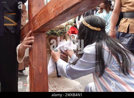 CUENCA-VIACRUSIS-SEMANA SANTA-TURI Cuenca, Ecuador 29 de marzo de 2024. Descalzo y con una cruz de madera de MAS de 200 libras sobre sus hombros, Marco Pintado recorrio las 14 estaciones del Via crucis de la parroquia Turi en Cuenca. El personifica a a Jesus desde hace anos, cuando heredo el legado de su padre, que Practice este rito por 14 anos, en la procesion en Honor al Senor de la Buena Muerte, una de las Mas tradicionales que se celebran en la Capital azuaya en Semana Santa. La procesion, que inicio a las 09:30 de hoy, viernes 29 de marzo de 2024, en los Tres Puentes, es liderada por un gru Stockfoto