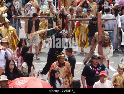 CUENCA-VIACRUSIS-SEMANA SANTA-TURI Cuenca, Ecuador 29 de marzo de 2024. Descalzo y con una cruz de madera de MAS de 200 libras sobre sus hombros, Marco Pintado recorrio las 14 estaciones del Via crucis de la parroquia Turi en Cuenca. El personifica a a Jesus desde hace anos, cuando heredo el legado de su padre, que Practice este rito por 14 anos, en la procesion en Honor al Senor de la Buena Muerte, una de las Mas tradicionales que se celebran en la Capital azuaya en Semana Santa. La procesion, que inicio a las 09:30 de hoy, viernes 29 de marzo de 2024, en los Tres Puentes, es liderada por un gru Stockfoto