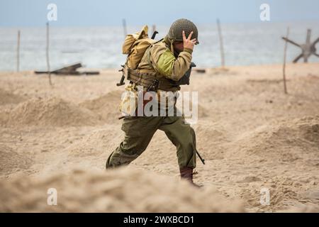 Historische Rekonstruktion. Ein US-amerikanischer Infanterie-Soldat aus dem Zweiten Weltkrieg, der am Strand kämpft. Stockfoto