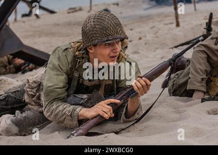 Historische Rekonstruktion. Ein US-amerikanischer Infanterie-Soldat aus dem Zweiten Weltkrieg, der am Strand kämpft. Stockfoto