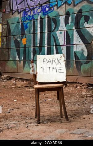 Auf einem alten Stuhl steht ein Schild, das darauf hinweist, dass kein Parkplatz vorhanden ist Stockfoto