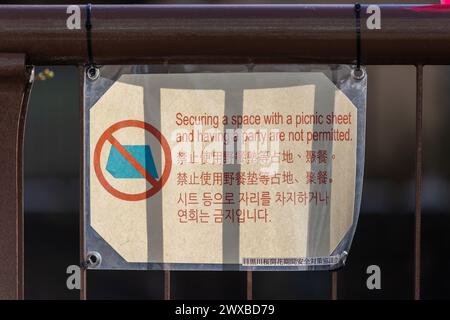 Tokio, Japan. März 2024. Ein Warnschild, da Bänke in der Nähe des Meguro River abgesperrt wurden, um zu verhindern, dass Menschen Orte retten, um den ganzen sonnigen Tag unter der blühenden Sakura zu verbringen. Mitglieder der Öffentlichkeit besuchen den Meguro River, um Kirschblüten zu sehen, die aufgrund des regnerischen und kalten Wetters noch nicht geblüht haben. Es wird erwartet, dass am nächsten Tag, am Wochenende, Kirschblüten blühen, wobei die Erwartungen an einen blühenden Blumentourismus bestehen. Quelle: Marcin Nowak/Alamy Live News Stockfoto