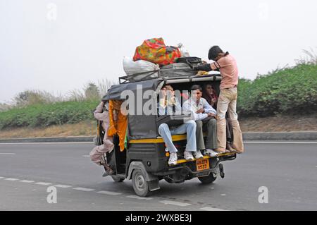 Personenbeförderung in einem überladenen Fahrzeug auf einer Straße, offenbar eine gängige Praxis, Jaipur, Rajasthan, Indien Stockfoto