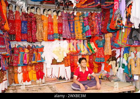Kamelmarkt, Messe, Menschen, Hochzeitsmarkt, Tiere, Wüstenstadt Pushkar (Pushkar Camal Fair), Ein Junge sitzt in einem Textilladen voller bunter Farben Stockfoto