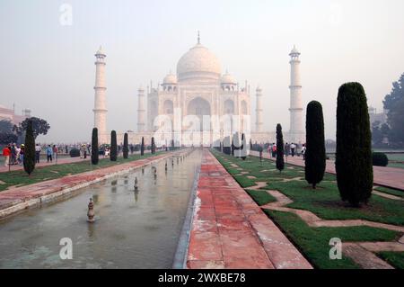 Das Taj Mahal im frühen Morgennebel mit Besuchern und Landschaftsgärten im Vordergrund, UNESCO-Weltkulturerbe, Agra, Uttar Pradesh, Indien Stockfoto