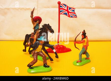 Retro-Spielzeuge von Cowboys und roten Indianern mit einer Union Jack Flagge Stockfoto