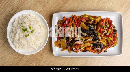 Appetitliches farbenfrohes Gemüse in asiatischer Art serviert mit weißem Reis auf Teller Stockfoto