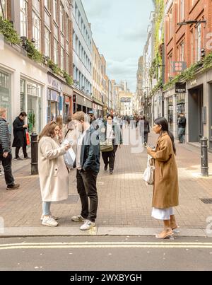 Shopper und Touristen in der Carnaby Street, dem legendären Zentrum, das Mode, Kultur und pulsierendes Straßenleben im Herzen von Soho, London, verbindet. Stockfoto