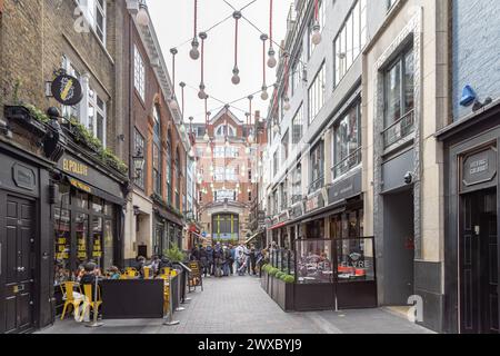 51 große Glühbirnen schweben über der Ganton Street und bilden eine permanente Kunstinstallation, während Einheimische und Touristen unten Essen und Getränke genießen. Stockfoto