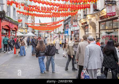 Wardour Street in Chinatown, London, voller Menschenmassen von Einkäufern und Touristen. Menschen, die unter chinesischen Laternen in Londons Chinatown spazieren. Stockfoto