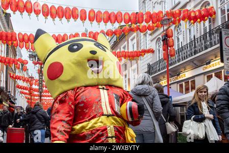 Die Pokémon-Figur Pikachu begrüßt Besucher am Eingang von Chinatown, London. Touristen werden in Chinatown vom Pokemon Pikachu begrüßt. Stockfoto