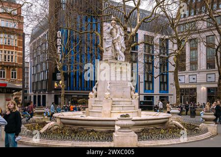 Eine Statue von William Shakespeare bildet seit 1874 das Herzstück der Leicester Square Gardens in London. Das ikonische Odeon Luxe-Kino auf der Rückseite. Stockfoto