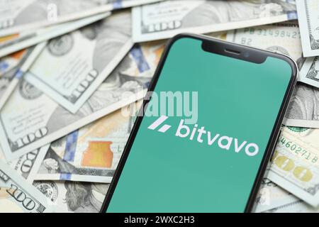 KIEW, UKRAINE - 15. MÄRZ 2024 Bitvavo-Logo auf dem iPhone-Display mit vielen Hundert-Dollar-Scheinen. Portal für den Austausch von Kryptowährungen Stockfoto