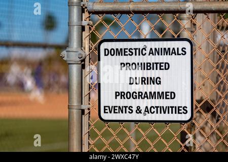 Schild am Maschendrahtzaun im Park, Haustiere sind während programmierter Veranstaltungen und Aktivitäten verboten Stockfoto