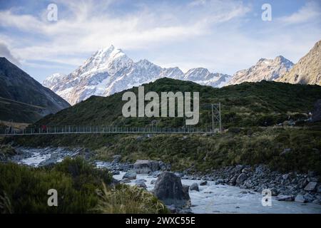 Touristen überqueren die Hängebrücke über dem Gletscherfluss in alpiner Umgebung, Mt Cook, Neuseeland. Stockfoto