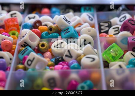 Runde farbige Ringe und Würfel mit Buchstaben für horizontale Schmuckarmbänder für Kinder Stockfoto