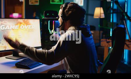 Wütender Gamer, der frustriert, nachdem er während des Videospiels im Raumschiff den Level verloren hat. Verärgerter Spieler, der wütend auf den Tisch schlägt, fliegende Raumfahrzeuge im Spiel zerstört, Spiel-über-Nachricht Stockfoto