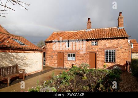 Hinter dem Cottage, in dem einst Mrs. Smith in Navenby, Lincolnshire, lebte, erscheint ein Regenbogen. Das von der örtlichen Gemeinde gerettete, bescheidene Haus von Mrs. Smith wurde 1999 erstmals als Museum eröffnet. Durch die Zusammenarbeit von lokalen Freiwilligen und dem District Council zieht die Stätte Besucher und Lob von weit und breit an. Stockfoto