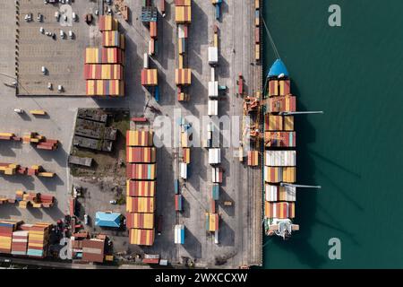 Luftaufnahme von oben auf das Containerschiff, das im Industriehafen beladen wird, Drohnenaufnahme. Stockfoto