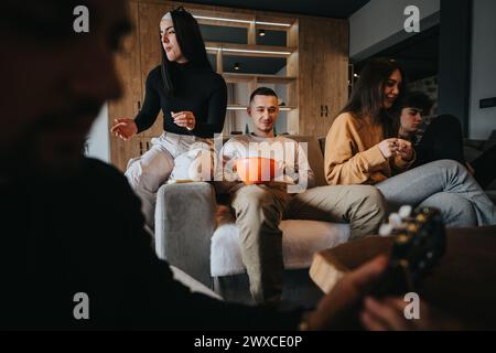 Junge Freunde verbringen Zeit miteinander, genießen Snacks und Musik zu Hause Stockfoto