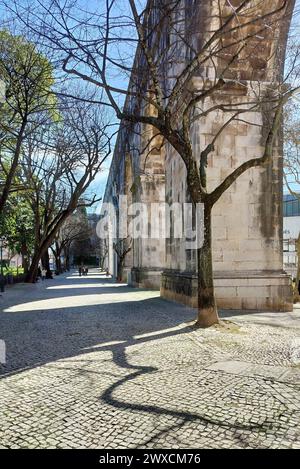 Steinbögen von Amoreiras Abschnitt des Aquädukts Aguas Livres, Kopfsteinpflasterweg im Garten Amoreiras bei Sonnenuntergang Licht und Schatten, Lissabon, Portugal Stockfoto