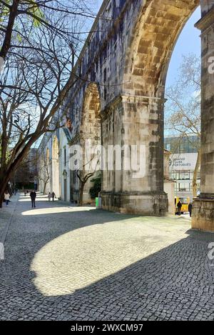 Steinbögen von Amoreiras Abschnitt des Aquädukts Aguas Livres, Kopfsteinpflasterweg im Garten Amoreiras bei Sonnenuntergang Licht und Schatten, Lissabon, Portugal Stockfoto