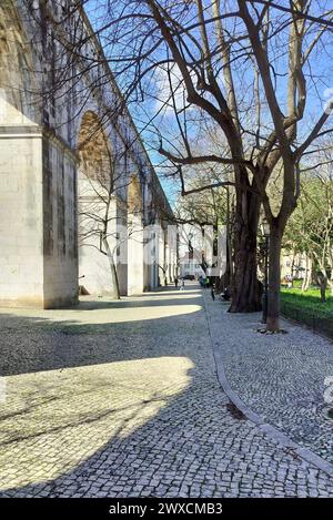 Steinbögen von Amoreiras Abschnitt des Aquädukts Aguas Livres, Kopfsteinpflasterweg im Garten Amoreiras bei Sonnenuntergang Licht und Schatten, Lissabon, Portugal Stockfoto