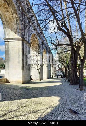 Steinbögen von Amoreiras Abschnitt des Aquädukts Aguas Livres, Kopfsteinpflasterweg im Garten Amoreiras bei Sonnenuntergang Licht und Schatten, Lissabon, Portugal Stockfoto