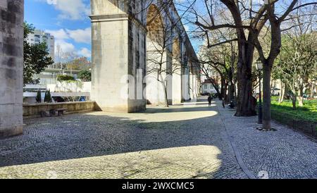 Steinbögen von Amoreiras Abschnitt des Aquädukts Aguas Livres, Kopfsteinpflasterweg im Garten Amoreiras bei Sonnenuntergang Licht und Schatten, Lissabon, Portugal Stockfoto