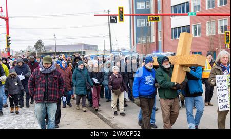 Edmonton, Kanada. März 2024. Die Teilnehmer tragen ein hölzernes Kreuz, während Tausende von Gläubigen auf dem Weg der Cross-Prozession durch die Innenstadt von Edmonton folgen. (Foto: Ron Palmer/SOPA Images/SIPA USA) Credit: SIPA USA/Alamy Live News Stockfoto