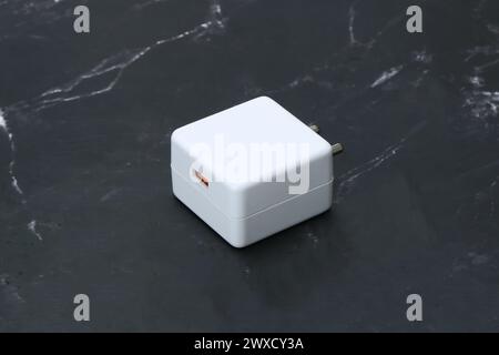 Zwei-Pin-Smatphone weiße Farbe Ladegerät isoliert auf schwarzem Marmorhintergrund Stockfoto
