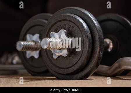 Alte, gebrauchte Gewichte im Fitnessstudio. Nahaufnahme mit getragener Hantel, Fitnessgeräten in heruntergekommenem Fitnessstudio. Stockfoto