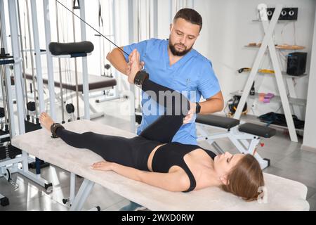 Ein erfahrener Kinesiologe verwendet einen speziellen Simulator, um mit dem Patienten zu arbeiten Stockfoto