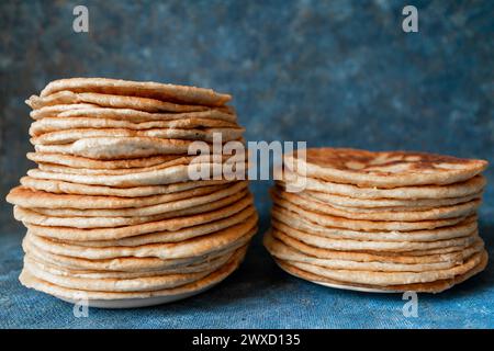 Fladenbrot Lavash, Chapati, Naan, ein Haufen Tortilla auf blauem Hintergrund hausgemachtes Fladenbrot gestapelt. Stockfoto