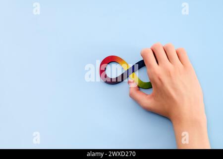 Autistische Boyhände und Regenbogenacht-Unendlichkeitssymbol. Autismus-Awareness-Tag-Symbol. Stockfoto