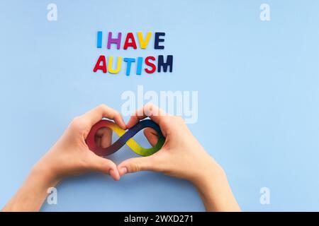 Autistische Boyhände und Regenbogenacht-Unendlichkeitssymbol. Autismus-Awareness-Tag-Symbol. Stockfoto