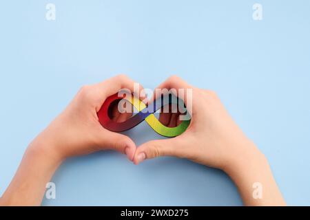 Autistische Boyhände und Regenbogenacht-Unendlichkeitssymbol. Autismus-Awareness-Tag-Symbol. Stockfoto