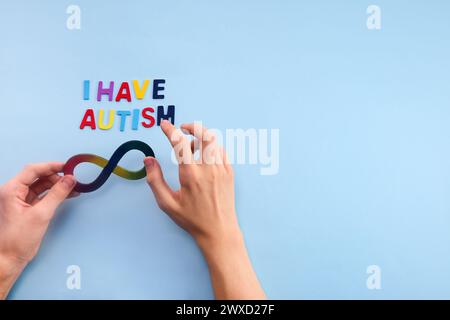 Autistische Boyhände und Regenbogenacht-Unendlichkeitssymbol. Autismus-Awareness-Tag-Symbol. Stockfoto