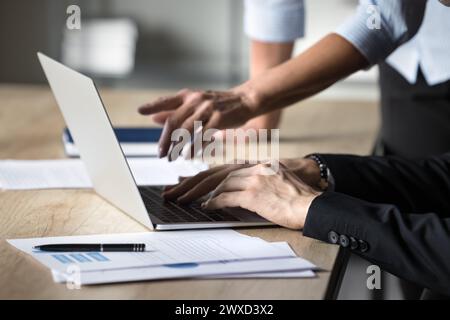 Hände von Geschäftskollegen, die gemeinsam an einem Projekt am Laptop arbeiten Stockfoto