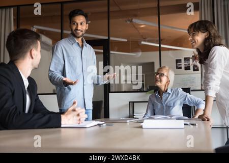 Fröhlich inspirierter junger indischer Profi-Mann, der einen Projektplan präsentiert Stockfoto