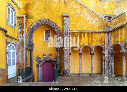 Innenraum des Bogenhofes mit wunderschön dekorierten Bögen und Säulen im arabischen Stil und den gelb bemalten Wänden des Pena Palace in Sint Stockfoto