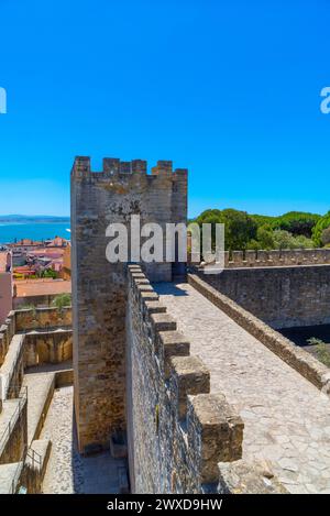 Blick von oben auf die Mauern, die Barbakane, die Mauer und den Fußweg zum Wachturm oder zur Hommage an das Schloss St. Georg mit einem Teil der typischen Häuser von Lissabon Stockfoto