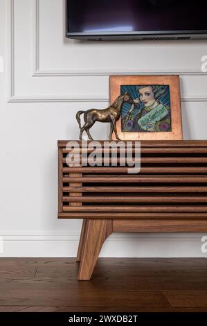Eine Statue eines Pferdes auf einem Holztisch vor einem Fernseher Stockfoto