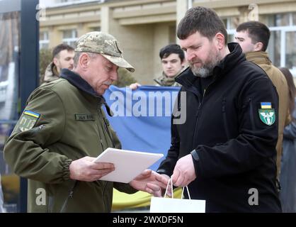 Nicht exklusiv: IRPIN, UKRAINE - 28. MÄRZ 2024 - der Stadtchef von Irpin, Oleksandr Markushyn (R), vergibt posthum Auszeichnungen an Verwandte verstorbener Defe Stockfoto