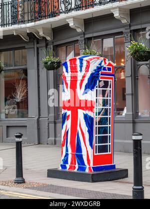 Das öffentliche Kunstwerk „Ring a Royal“ von Timmy Mallett, eine Telefonbox in Union Jack Farben mit Prince Harry, in High Street, Windsor, Berkshire, Großbritannien Stockfoto