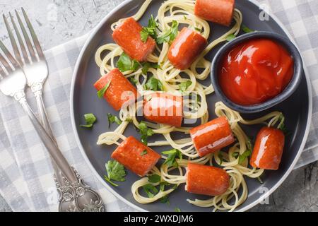 Wiener und Noodle Spider Snacks mit Ketchup Nahaufnahme auf einem Teller auf dem Tisch. Horizontale Draufsicht von oben Stockfoto