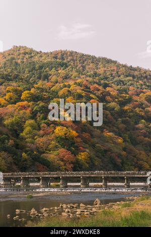 Arashiyama, Kyoto, Herbstlaub auf Hügeln in der Landschaft mit Togetsu-kyo-Brücke Stockfoto