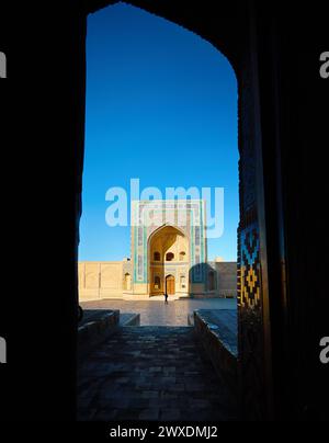 Wunderschöner Blick auf das Wahrzeichen der Außenmadrasah von Abdulaziz Khan und das touristisch gerahmte Arch Gate in der Altstadt von Bokhara, Usbekistan Stockfoto